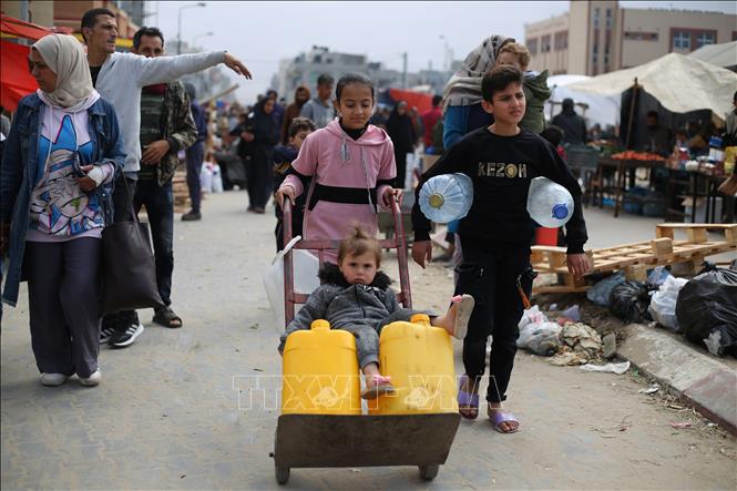 Trẻ em đi lấy nước tại vòi nước công cộng ở thành phố Rafah, Dải Gaza, ngày 18/3/2024. Ảnh: THX/TTXVN