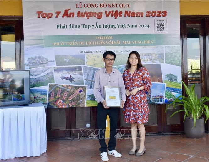 Ban tổ chức trao chứng nhận cho tác giả Dương Việt Anh với tác phẩm “Cánh đồng lúa chín ở thị xã Tịnh Biên” Top 7 cảnh đẹp bất ngờ nhìn từ không trung năm 2023. Ảnh: TTXVN phát