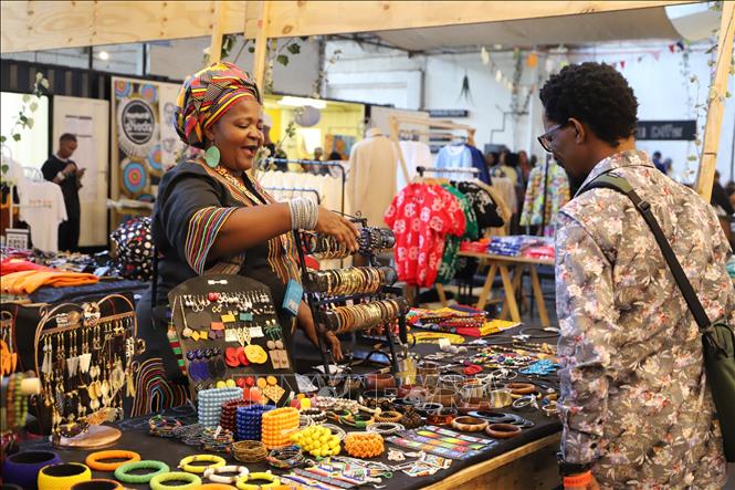 Một người bán hàng thủ công châu Phi giới thiệu sản phẩm cho khách tại chợ Market@TheSheds. Ảnh: Hồng Minh - PV TTXVN tại Nam Phi