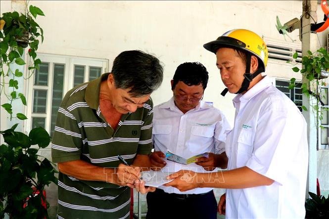 Ông Nguyễn Thanh Thảo tại thị trấn Thạnh An (Vĩnh Thạnh, Cần Thơ) ký xác nhận đã tiêm phòng bệnh dại cho chó nuôi của gia đình. Ảnh: Thu Hiền - TTXVN