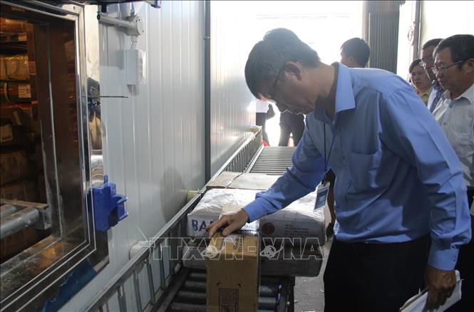 Cán bộ trong đoàn kiểm tra liên ngành về an toàn thực phẩm tỉnh Khánh Hòa kiểm tra về nhãn mác, tem phụ của hàng đông lạnh nhập khẩu của Cơ sở đông lạnh Minh Nhật Food NT, sáng 8/4. Ảnh: Phan Sáu -TTXVN