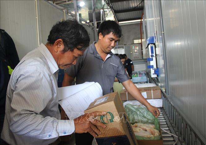 Cán bộ trong đoàn kiểm tra liên ngành về an toàn thực phẩm tỉnh Khánh Hòa cùng đại diện doanh nghiệp thông tin về mẫu cánh gà cho đoàn kiểm tra làm việc, sáng 8/4. Ảnh: Phan Sáu -TTXVN