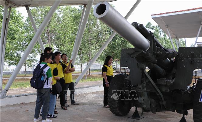 Sinh viên đến tìm hiểu hiện vật trưng bày ngoài trời tại Khu di tích Chiến thắng Chương Thiện. Ảnh: Hồng Thái - TTXVN