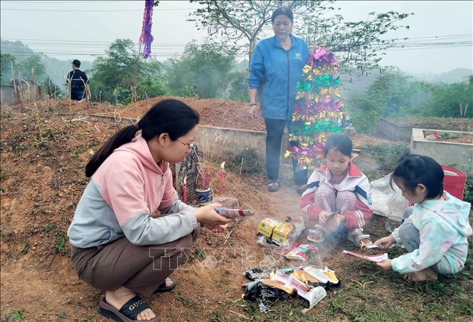 Nhiều trẻ em cũng được gia đình cho đi theo tảo mộ. Ảnh: Nguyễn Công Hải – TTXVN