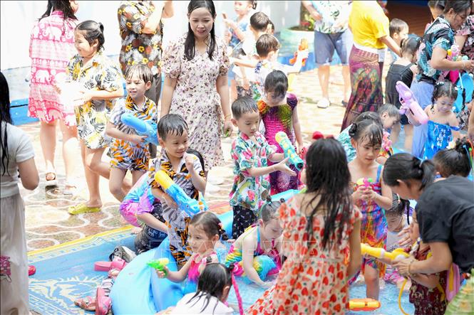 Cô và trò một trường học tại thủ đô Viêng Chăn tham gia hoạt động té nước. Ảnh: Đỗ Bá Thành - PV TTXVN tại Lào
