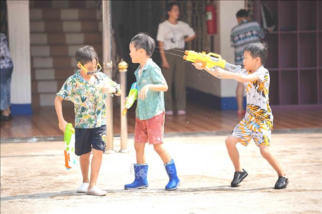 Học sinh các trường học ở thủ đô Viêng Chăn vui đùa trong lễ té nước truyền thống. Ảnh: Đỗ Bá Thành - PV TTXVN tại Lào
