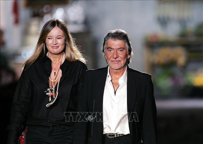 Nhà thiết kế huyền thoại Roberto Cavalli (phải) cùng vợ Eva tại tuần lễ thời trang Xuân/Hè Milan, ngày 2/10/2004. Ảnh: AFP/TTXVN
