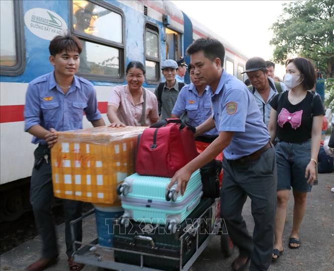 Nhân viên trên đường sắt hỗ trợ hành khách trên tàu SE5 mang hành lý lên xe trung chuyển ở ga Tuy Hòa. Ảnh: Xuân Triệu - TTXVN