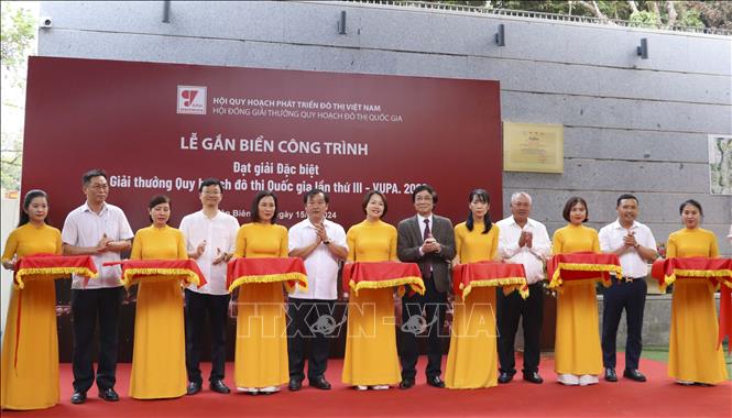 Các đại biểu cắt băng khánh thành tại lễ gắn biển công trình đạt giải Đặc biệt giải thưởng Quy hoạch đô thị Quốc gia lần thứ III đối với Đền thờ Liệt sĩ Chiến trường Điện Biên Phủ. Ảnh: TTXVN phát