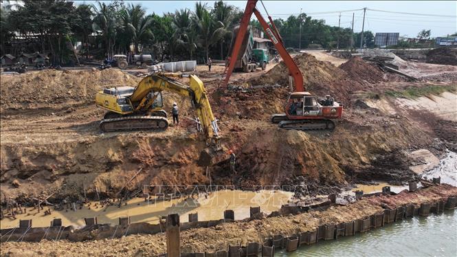  Đơn vị thi công đẩy nhanh tiến độ thi công công trình bờ kè chống sạt lở suối Cần Đăng. Ảnh: Thanh Tân - TTXVN