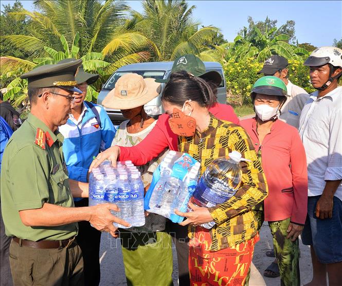 Công an tỉnh Cà Mau tặng nước uống cho người dân huyện Trần Văn Thời. Ảnh: Huỳnh Anh - TTXVN