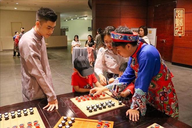 Giới trẻ tìm hiểu về bộ cờ Mặt trời. Ảnh: TTXVN phát