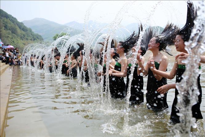 Các thiếu nữ dân tộc Thái trắng thực hiện màn gội đầu truyền thống đặc sắc trong lễ hội. Ảnh: Quý Trung – TTXVN