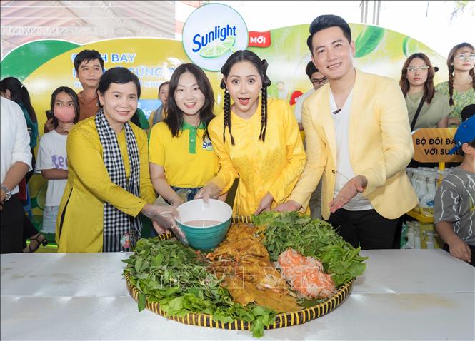 Visitors enjoy free banh xeo (sizzling rice pancake) at the event. VNA Photo: Thanh Liêm