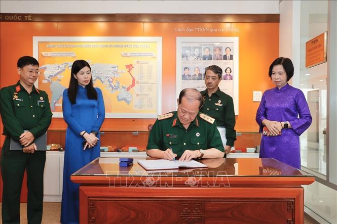 Thượng tướng Bế Xuân Trường, Chủ tịch Hội Cựu chiến binh Việt Nam ghi sổ lưu niệm tại phòng truyền thống TTXVN. Ảnh: Minh Quyết - TTXVN