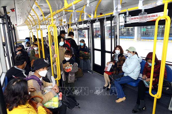 Visitors on a shuttle bus to the airplane at Noi Bai International Airport. VNA Photo: Huy Hùng