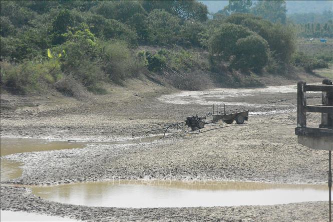 Người dân xã Cư Pui, huyện Krông Bông bơm những vũng nước còn lại của hồ chứa Ea Hmun để chống hạn cho cây trồng. Ảnh: Tuấn Anh – TTXVN