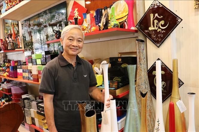 Lacquer artisan Le Ba Linh, Vice President of Binh Duong Association of Lacquer and Sculpture, owner of Tu Bon Lacquerware Enterprise, next to his lacquer products. VNA Photo: Dương Chí Tưởng