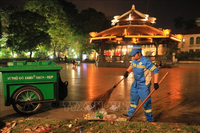 A Worker collects waste in a street in Hanoi. VNA Photo: Hoàng Hiếu