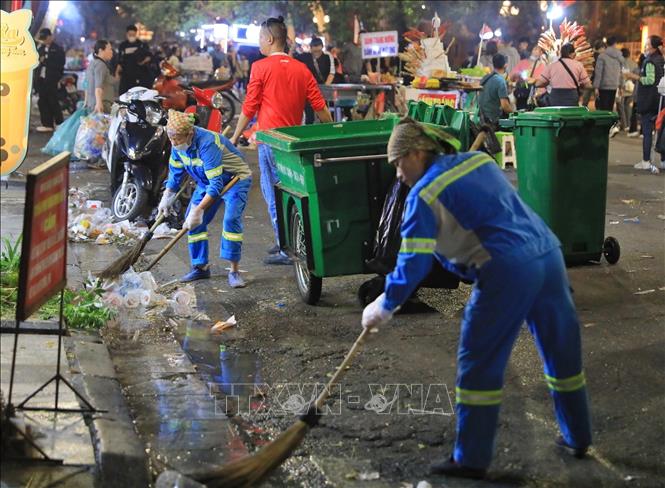 Workers collect waste in a street in Hanoi. VNA Photo: Hoàng Hiếu