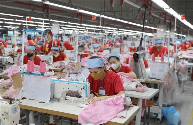 Hàng ngàn công nhân Công ty TNHH Wooin Vina (Cụm công nghiệp Tháp - Hồng - Kỷ, huyện Diễn Châu) mặc áo màu đỏ sao vàng trong các ca làm vào sáng thứ hai. Ảnh: Xuân Tiến - TTXVN