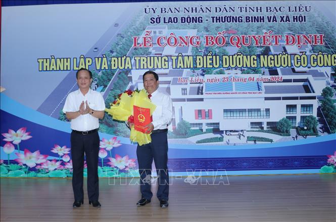 Chủ tịch UBND tỉnh Bạc Liêu Phạm Văn Thiều trao quyết định và tặng hoa cho Giám đốc Trung tâm điều dưỡng Người có công tỉnh Bạc Liêu. Ảnh: Tuấn Kiệt - TTXVN