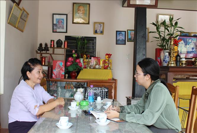 Phóng viên TTXVN trò chuyện với bà Nguyễn Thị Ngọc Bích, em gái liệt sĩ Nguyễn Thị Ngọc Oanh về sự kiện gia đình bà may 2 lá cờ giải phóng trước những năm 1975. Ảnh: Phan Sáu - TTXVN