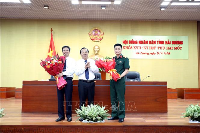 Phó Bí thư thường trực Tỉnh ủy, Chủ tịch HĐND tỉnh Hải Dương Lê Văn Hiệu (đứng giữa) tặng hoa chúc mừng Đại tá Vũ Hồng Anh, Chỉ huy trưởng Bộ Chỉ huy Quân sự tỉnh Hải Dương (bên phải) được bầu là Ủy viên UBND tỉnh Hải Dương nhiệm kỳ 2021-2026. Ảnh: Mạnh Tú - TTXVN
