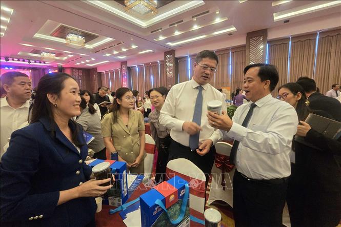 Chủ tịch UBND tỉnh Cà Mau Huỳnh Quốc Việt (phải) giới thiệu sản phẩm OCOP Cà Mau đến ông Ngụy Hoa Tường, Tổng Lãnh sự quán Trung Quốc tại Thành phố Hồ Chí Minh. Ảnh: Kim Há-TTXVN 