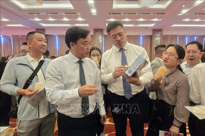 Chairman of the provincial People's Committee Huynh Quoc Viet and Consul General of China in Ho Chi Minh City Wei Huaxiang view the showcase of Ca Mau's OCOP products. VNA Photo: Kim Há