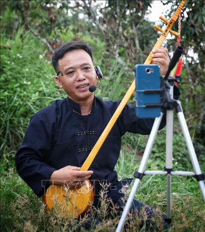 Nghệ nhân ưu tú Lục Văn Tích biểu diễn hát Then, đàn tính livestream trên nền tảng mạng xã hội. Ảnh: Danh Lam - TTXVN