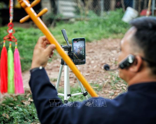 Nghệ nhân ưu tú Lục Văn Tích biểu diễn hát Then, đàn tính livestream trên nền tảng mạng xã hội. Ảnh: Danh Lam - TTXVN