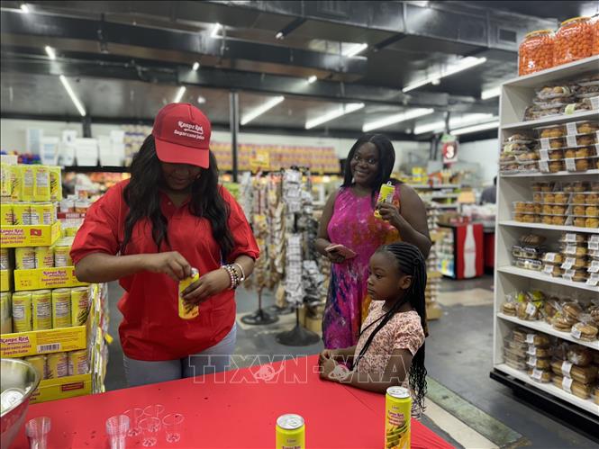 Customers taste Kanpe Red sugarcane juice at Miami's supermarket. VNA Photo: Kiều Trang