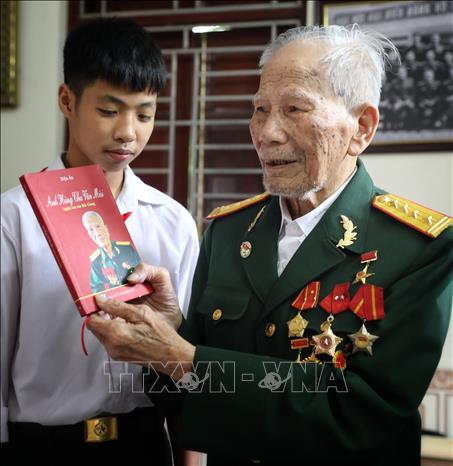 Anh hùng Chu Văn Mùi cùng quyển hồi kỳ. Ảnh: Danh Lam-TTXVN