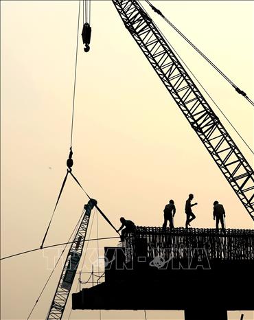 Hơn 200 cán bộ, công nhân ngày đêm làm việc nhằm đảm bảo tiến độ thi công cầu Núi Đọ. Ảnh: Huy Hùng - TTXVN
