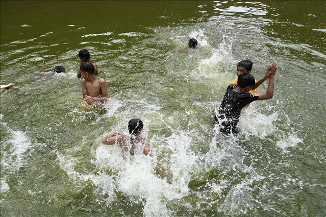 Trẻ em tắm ao tránh nóng tại Dhaka, Bangladesh ngày 17/4/2024. Ảnh: AFP/TTXVN