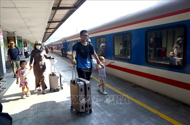 Nhiều gia đình có trẻ em lựa chọn đi tàu về quê và đi du lịch. Ảnh: Huy Hùng - TTXVN