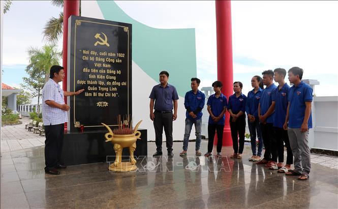 Đoàn viên thanh niên huyện Vĩnh Thuận, tỉnh nghe thuyết minh giới thiệu về di tích lịch sử Nơi thành lập Chi bộ Đảng Cộng sản Việt Nam đầu tiên của tỉnh Kiên Giang. Ảnh: Văn Sĩ - TTXVN