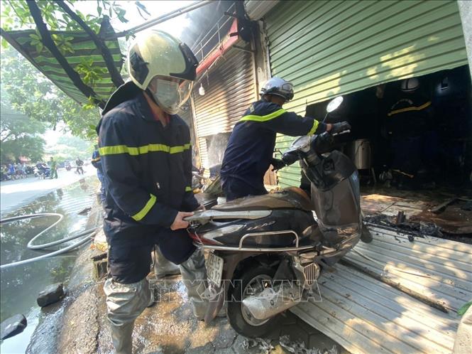Lực lượng chữa cháy đưa tài sản ra khỏi hiện trường. Ảnh: TTXVN phát