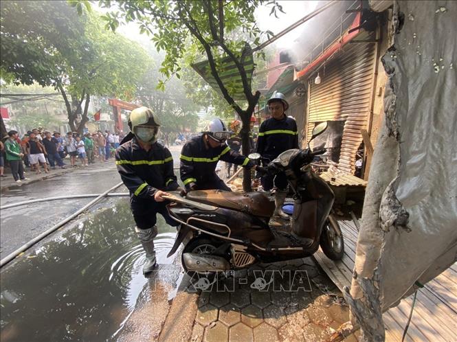 Lực lượng chữa cháy đưa tài sản ra khỏi hiện trường. Ảnh: TTXVN phát