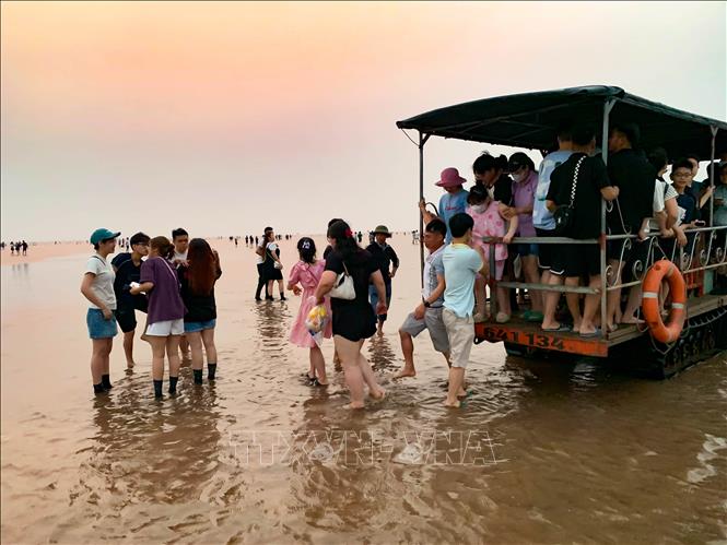 Du khách di chuyển ra biển vô cực bằng xe tự chế. Ảnh: Vũ Quang – TTXVN  