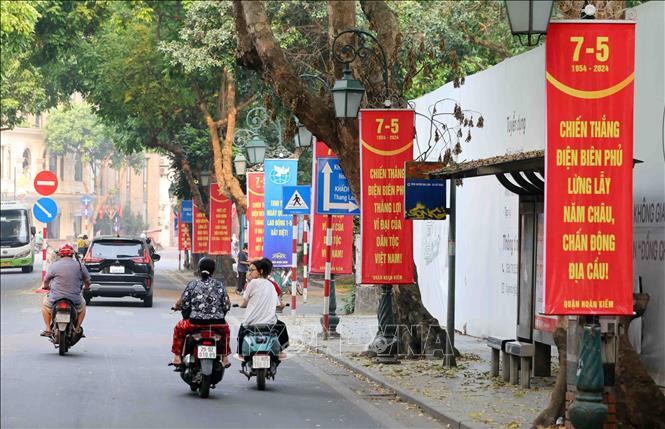 Red panels and banners on the street celebrate the 49th anniversary of the National Reunification Day (April 30, 1975 - 2024) and the 70th anniversary of the Dien Bien Phu Victory (May 7,1954 - 2024). VNA Photo: Phạm Kiên