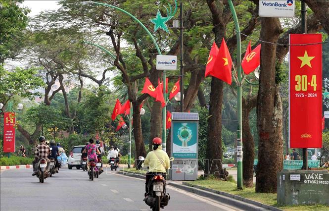 Thanh Nien street is decorated with national flags and red banners on the National Reunification Day. VNA Photo: Phạm Kiên