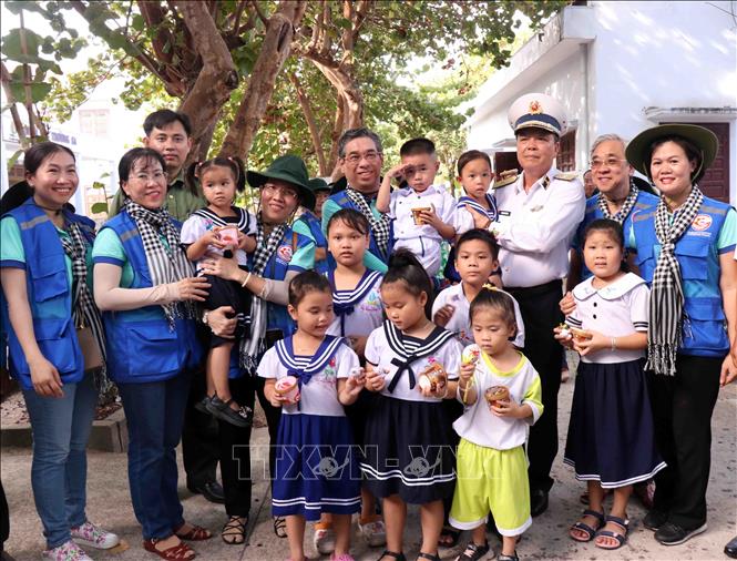 Chuẩn Đô đốc Phạm Như Xuân, Phó Tư lệnh Hải quân cùng Phó Bí thư Thành ủy Thành phố Hồ Chí Minh Nguyễn Phước Lộc và thiếu nhi trên đảo Trường Sa lớn. Ảnh: Xuân Khu-TTXVN