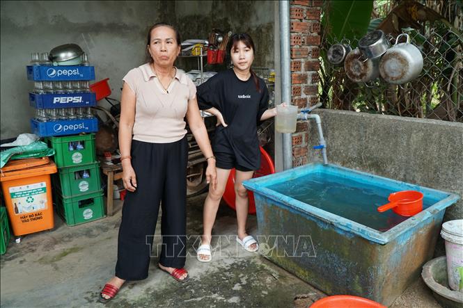 Gia đình bà Nguyễn Thị Chín (khu tái định cư thôn Nam Yên, xã Hòa Bắc, huyện Hòa Vang, thành phố Đà Nẵng) phải trữ nước vào bể nhựa, để lắng cặn bẩn trước khi sử dụng. Ảnh: Quốc Dũng - TTXVN