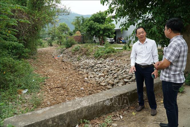 Phó chủ tịch UBND xã Hòa Bắc Trương Thanh Nhân (áo trắng, bên trái) cho biết hệ thống cấp nước tại xã lấy nguồn từ các khe suối tự nhiên, nên vào mùa khô thường xuyên bị tình trạng nước yếu hoặc không có nước. Ảnh: Quốc Dũng - TTXVN