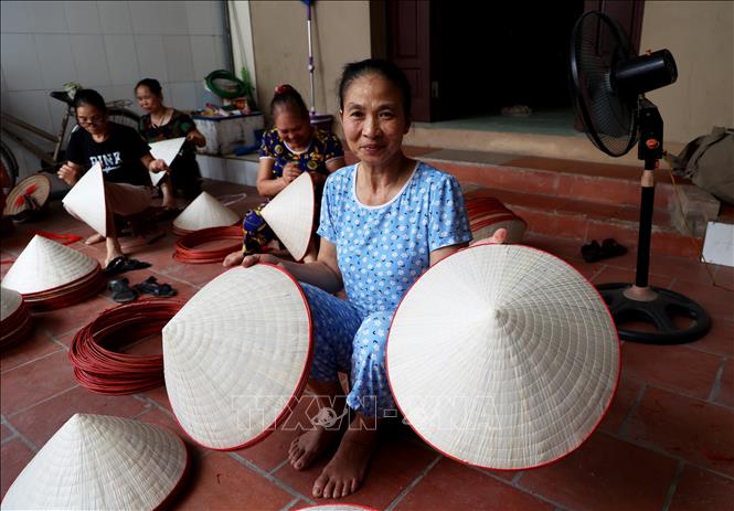 Bà Trần Thị Bình, 60 tuổi (thôn Phú Xuyên, xã Phú Châu, huyện Ba Vì, thành phố Hà Nội) đã có 50 năm làm nghề may nón lá. Ảnh: Hồng Đạt - TTXVN
