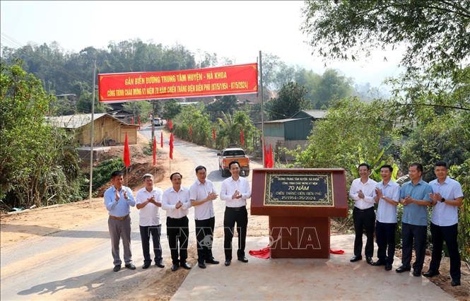 Các đại biểu gắn biển công trình đường Trung tâm huyện - Nà Khoa. Ảnh: Trung Kiên - TTXVN