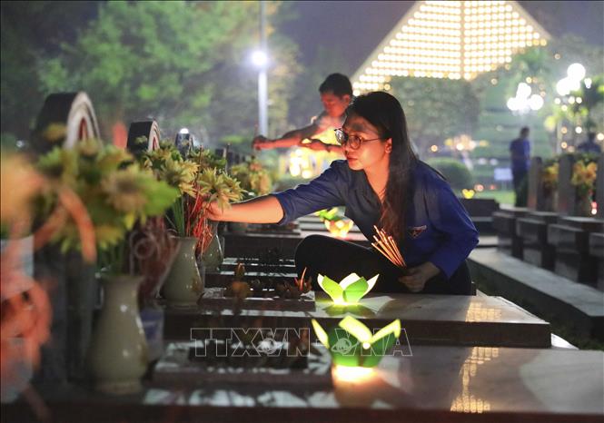 Đoàn viên thanh niên thắp hương lên các phần mộ liệt sĩ. Ảnh: Xuân Tư - TTXVN