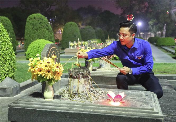 Đoàn viên thanh niên thắp hương lên các phần mộ liệt sĩ. Ảnh: Xuân Tư - TTXVN